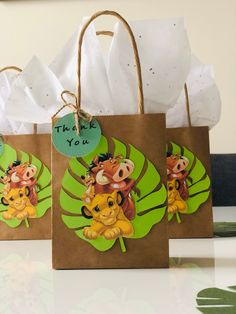 three small bags decorated with cartoon animals on them, one has a thank you tag