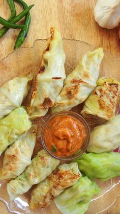 some food is sitting on a glass plate with sauce in the middle and garnishes around it