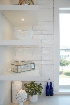 the shelves in the kitchen are filled with vases and other decorative items on them