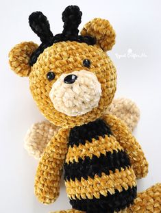 a crocheted teddy bear with black and yellow stripes