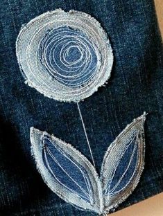 a pair of jeans with embroidered flowers on them