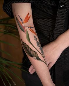 a woman's arm with flowers and leaves painted on the side of her body