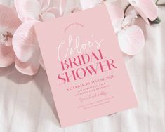 a pink bridal shower card next to flowers