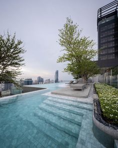 an outdoor swimming pool with steps leading up to it and trees in the foreground