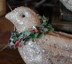 a white bird is decorated with holly and berries