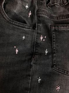 a pair of black jeans with pink and white stars on them