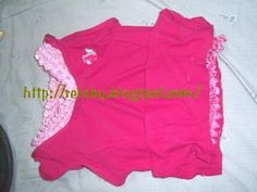 a pink shirt with ruffles on the bottom is laying on a white sheet