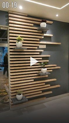 the wall is made out of wooden slats and has planters on each side