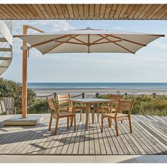 an outdoor table and chairs on a deck overlooking the ocean