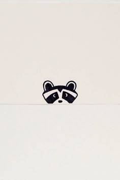 a raccoon sticker sitting on top of a white surface