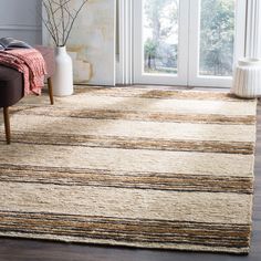 a living room area with a rug, chair and vase in front of the door