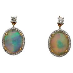 Magic Rainbow Dropping from Ears Mesmerizing Opals are the star of these ear drops Designed as swinging oval drops with two Opals surrounded by a halo of Diamonds topped by a small solitaire – hand crafted of solid 18 KT gold Two deep cut natural Jelly Opals of approx 4.20 Ct – displaying mesmerizing effect of rainbow colours, impressive, magic, the jelly catches so many colour hues hitting the light, simply enchanting with a thin line of sparkly Diamonds adding extra glow to the two powerful Opals Diamonds are . 15 CT over the top for the two solitaires and 60 in number tiny Diamonds for approx .30 Ct G VVS/VS Measures: 17 x 10 mm. (h. x w.) Fine condition – approx 1980 ca – lot of swing Further Details Below Metal: 18 Kt gold, tested Hallmarks: none/worn – assay on the fasteners Gems: 2 Magic Rainbow, Jelly Opal, Ear Drops, Diamond Top, Tiny Diamond, I Love Jewelry, Drops Design, Oval Cabochon, Brilliant Cut Diamond