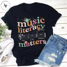 Product details:  TITLE NAME: Music Literacy Matters Teacher Vintage T-Shirt, Teacher Shirt, Teacherlife Shirt, Teacher Lovers Shirt, Music Teacher Shirt  IMPORTANT NOTE: Both Men and Women can we our shirts because this is unisex style t-shirts;  Wash item inside out in cold water, do not bleach, do not dry clean, do not iron directly on the design.  MATERIAL: 5.3-ounce, 100% cotton (99/1 cotton/poly (Ash) & 90/10 cotton/poly (Sport Grey); Heavyweight classic unisex tee; Taped neck and shoulder Music-themed Cotton Slogan Tops, Music-themed Cotton Tops With Slogan, Music-themed Cotton Top With Text Print, Music Festival Cotton T-shirt With Letter Print, Letter Print Cotton T-shirt For Music Festival, Cotton T-shirt With Letter Print For Music Festival, Spring Music-themed Letter Print Tops, Spring Cotton Tops With Music-themed Style, Spring Music-themed Cotton Tops