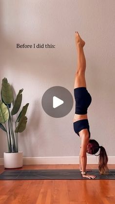 a woman doing a handstand on a yoga mat in front of a potted plant