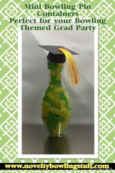 a green and white graduation cap sitting on top of a vase filled with candy