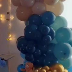 there are many balloons in the room and one is blue, gold and white with an elephant on it