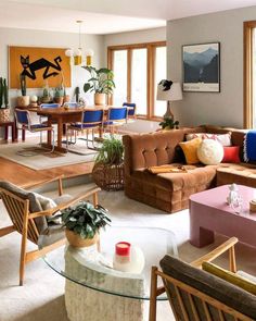 a living room filled with lots of furniture and plants on top of it's tables