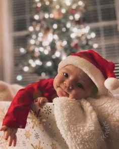 a baby wearing a santa hat and holding a present