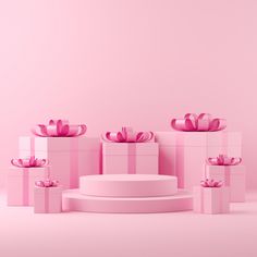 pink and white gift boxes with bows on the top in front of a light pink background