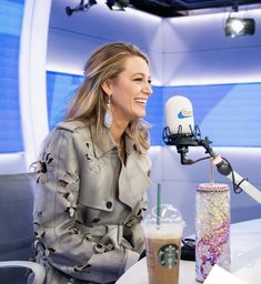 a woman sitting at a table in front of a microphone and talking on the radio