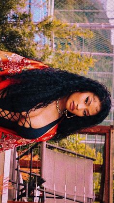 a woman with long black hair wearing a red and white dress posing for a photo