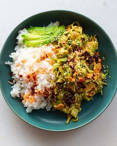 a blue plate topped with rice and vegetables