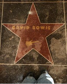 a person standing in front of a star on the ground with words david bowe written on it