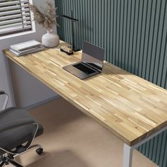 a laptop computer sitting on top of a wooden desk next to a black office chair