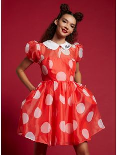 a woman in an orange dress with white polka dots on it and her hands on her hips