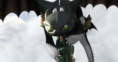 a black dragon with green eyes is perched on top of a building in the sky