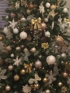 a decorated christmas tree with gold and silver ornaments