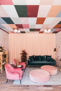 a living room filled with furniture next to a wall covered in multicolored tiles