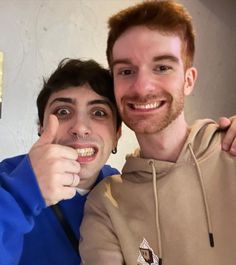 two people posing for the camera with one holding a pencil in front of his face