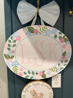 two plates are hanging on the front door and one is decorated with a dog's name