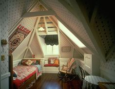 an attic bedroom with two beds and a rocking chair