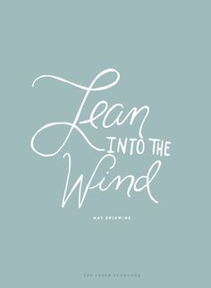 the words learn into the wind are shown in white on a blue background with a handwritten