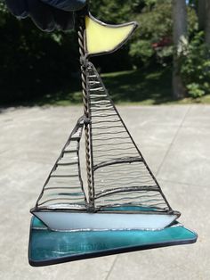 a wind chime with a sailboat on it's side in the air