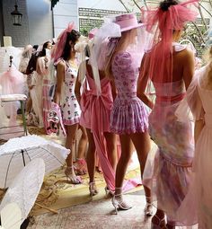 several women in dresses and veils walk down the catwalk at a fashion show