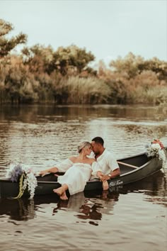 a bride and groom in a row boat on the water