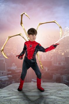 a young boy dressed as spider - man standing on top of a building