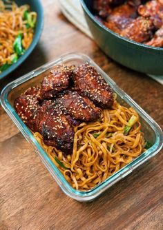 some food is in a plastic container on a table next to another bowl with noodles and meat