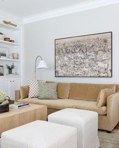 a living room filled with furniture and a painting on the wall