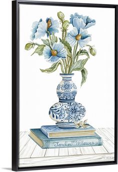 a blue and white vase with flowers in it on top of a stack of books