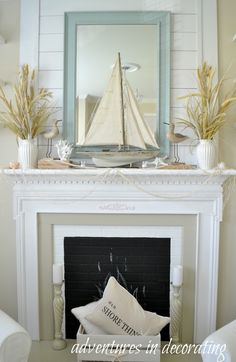 a living room with a fire place and a sailboat on the mantel above it