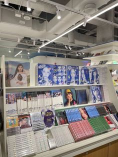 a book store filled with lots of books on shelves next to a wall covered in posters