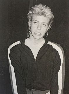 black and white photograph of a woman with blonde hair wearing a hoodie, sitting on a chair