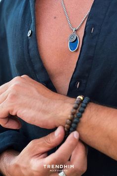 A man wearing a summer blue necklace and a brown bracelet that highlight his tanned skin. Tan Skin Tone, Tanned Skin, Brown Agate, Men's Bracelets, Anchor Bracelet, Wide Bracelet, Engraved Bracelet, Leather Cuffs Bracelet