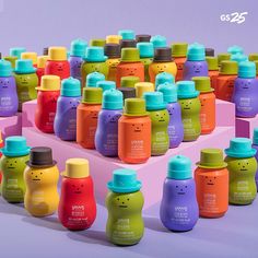 many different colored baby bottles are arranged on a pink and purple background with the same color