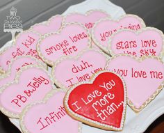 some cookies that are on a plate with words written on them and hearts in the middle