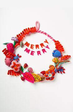 a colorful necklace with the words merry written in white and red letters on it's side